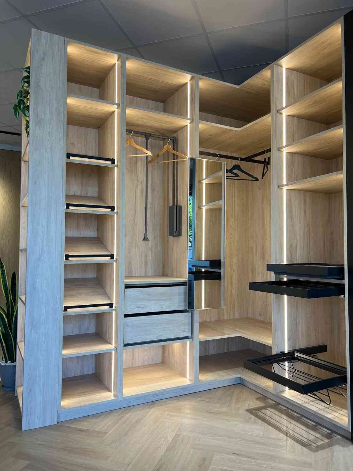 Vestidor abierto de madera con estantes, cajones, barras para colgar ropa y zapateros extraíbles.