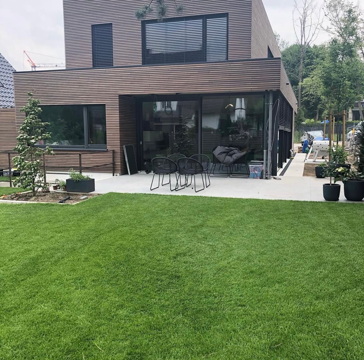 Im Vordergrund ist ein Holzdeck und im Hintergrund eine Wiese zu sehen.