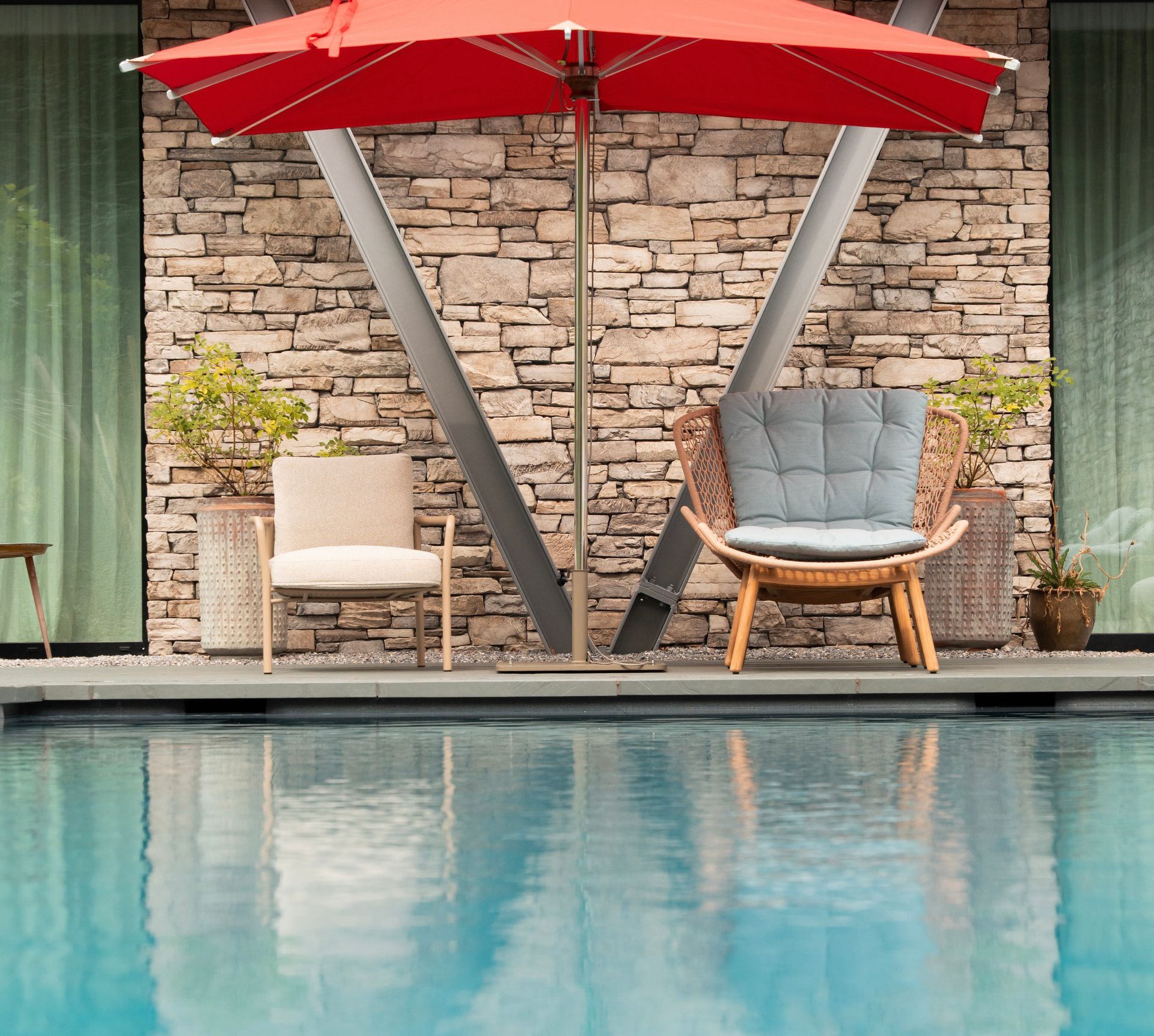 Ein Tisch und Stühle stehen auf einer Terrasse neben einem Teich.