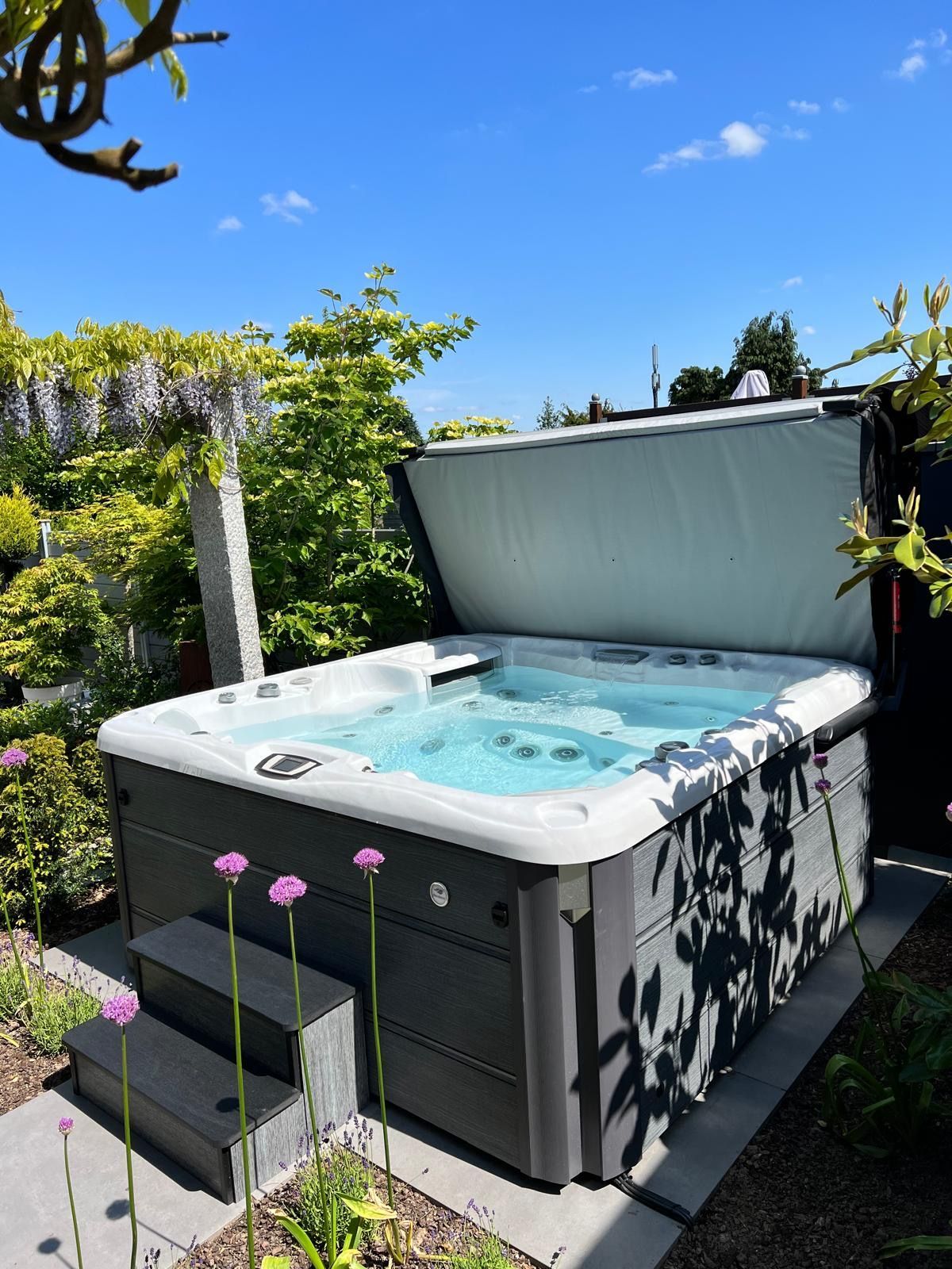 Auf einem Holzdeck steht ein Whirlpool.