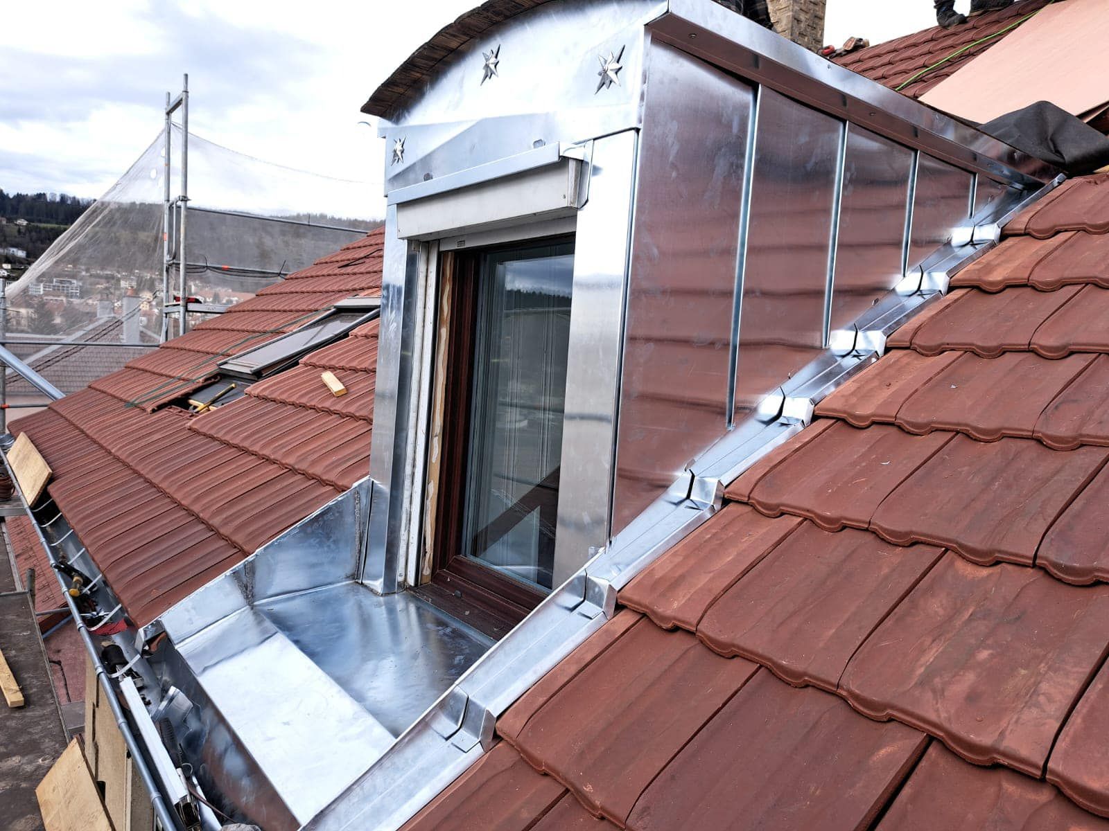 Travaux de zinguerie sur un toit avec une porte fenêtre