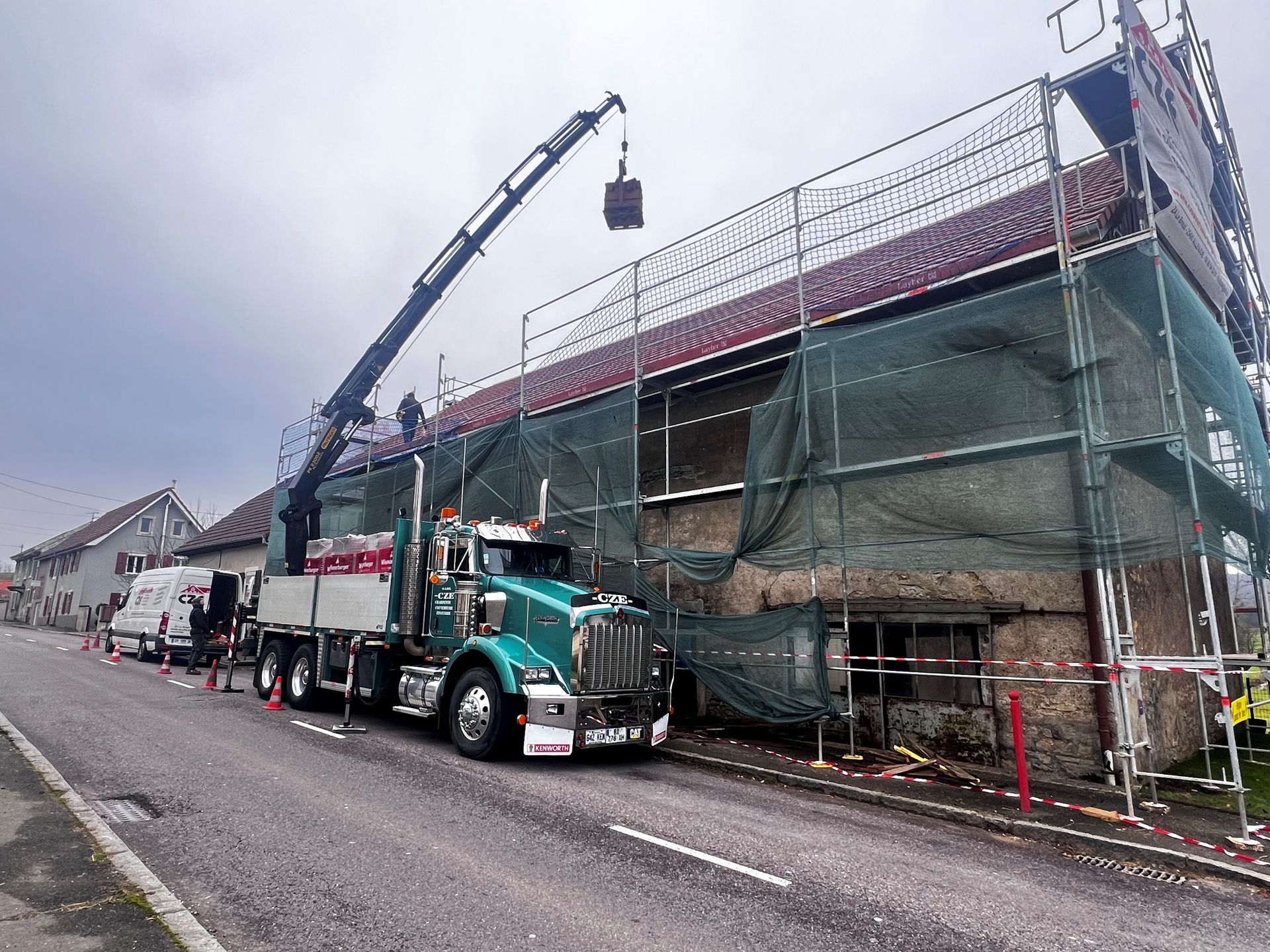 Camion-grue posant les tuiles sur un toit