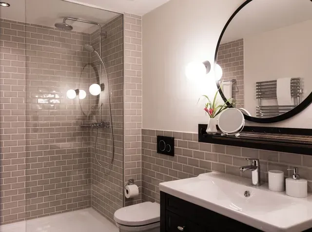 Ein Badezimmer mit Toilette, Waschbecken, Spiegel und Dusche.