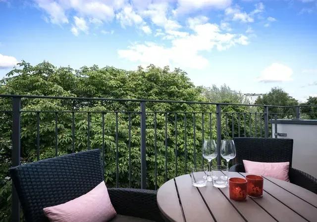 Ein Balkon mit Tisch und Stühlen und Blick auf Bäume