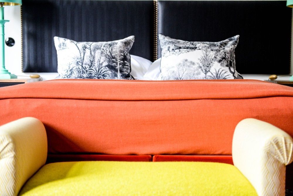 Ein Bett mit einer gelben Bank davor