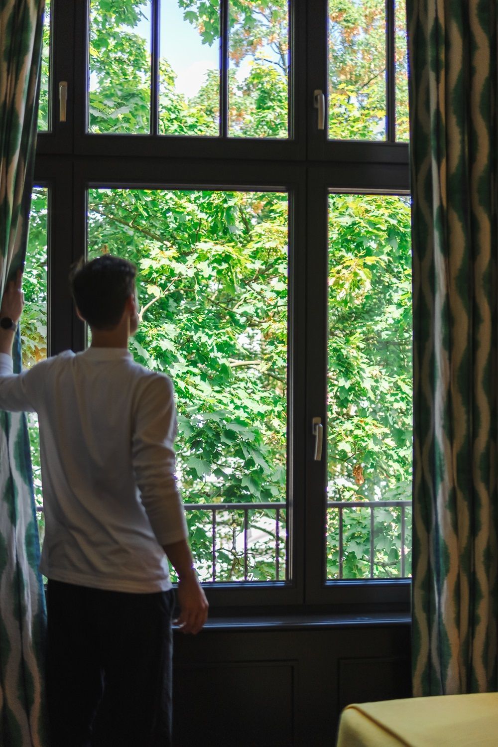 Ein Mann steht vor einem Fenster und schaut hinaus.