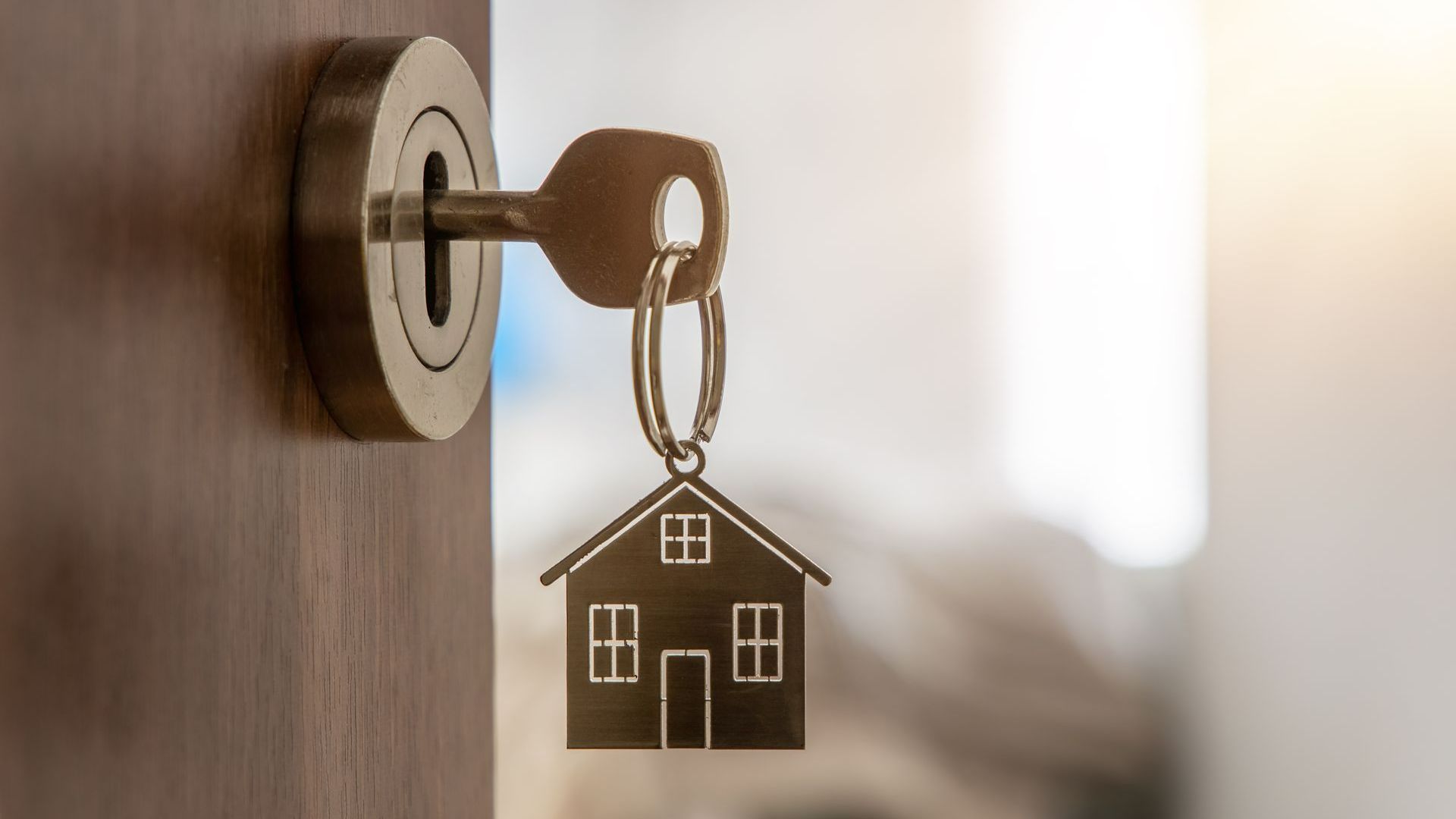 Une clé avec une maison dans la serrure d’une porte