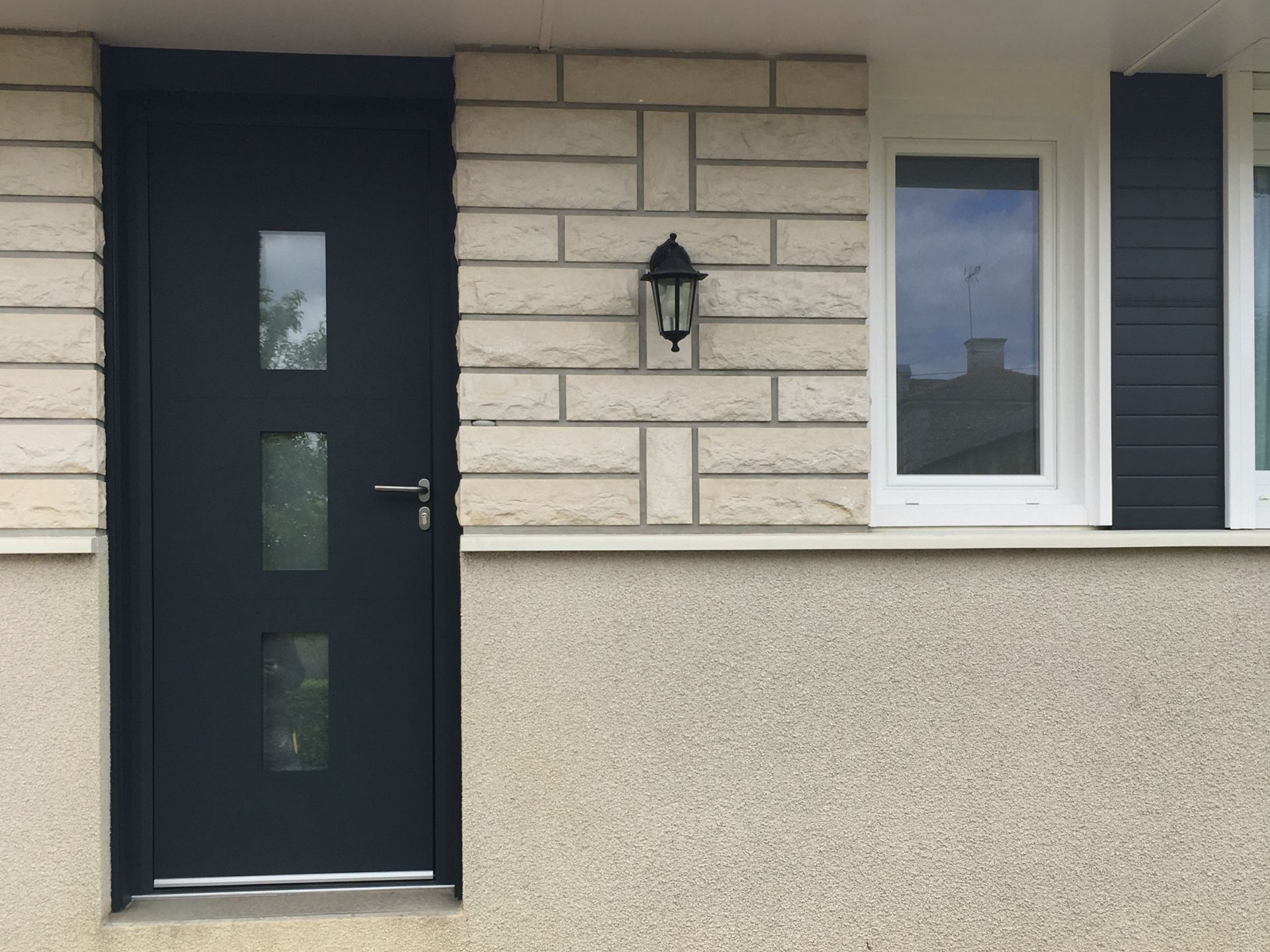 Une porte en alu et une petite fenêtre