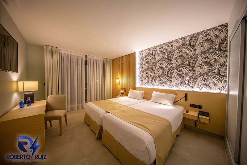 Una habitación de hotel con dos camas, un escritorio, una silla y un televisor.