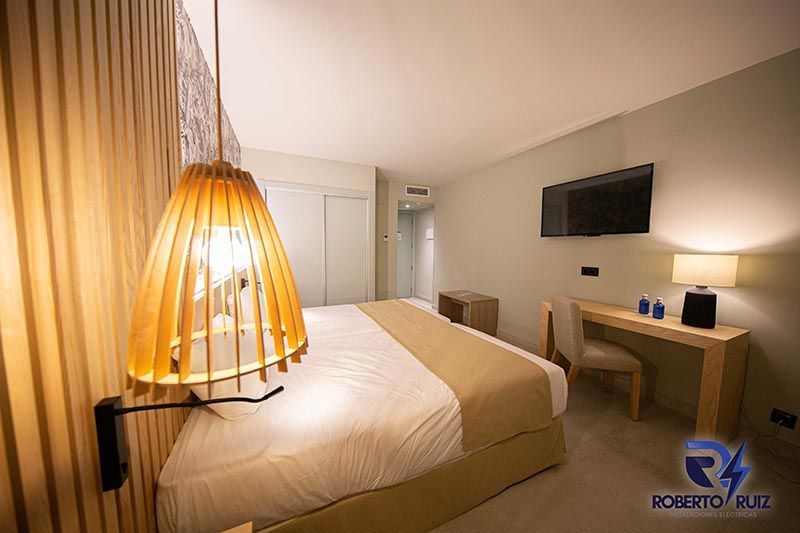 Una habitación de hotel con una cama tamaño king, escritorio, silla y televisión.