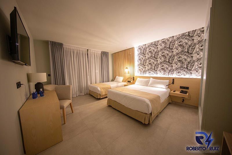 Una habitación de hotel con dos camas, un escritorio y un televisor.