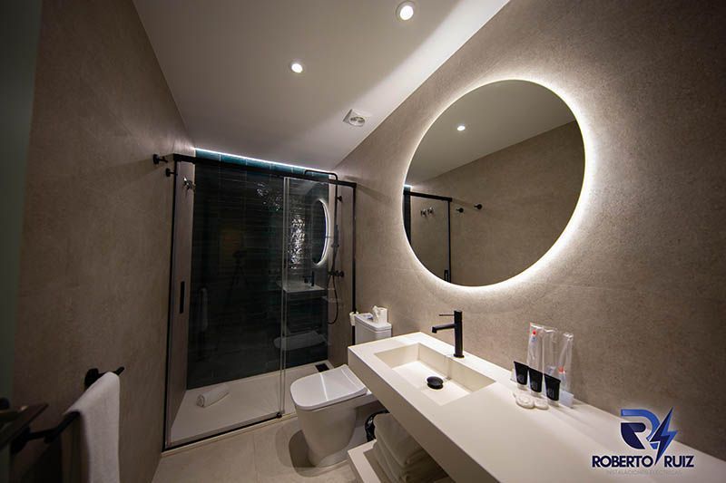 Un baño con lavabo, inodoro, ducha y espejo.