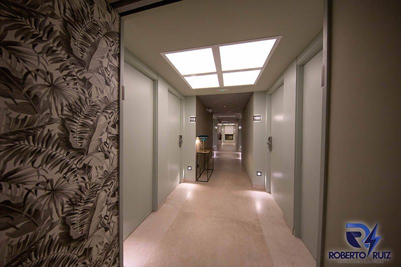 Un pasillo largo con puertas blancas y una luz de techo.