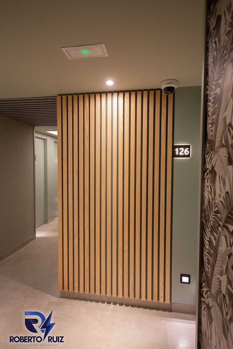 Un pasillo con una pared de madera y un número 126 en la pared.