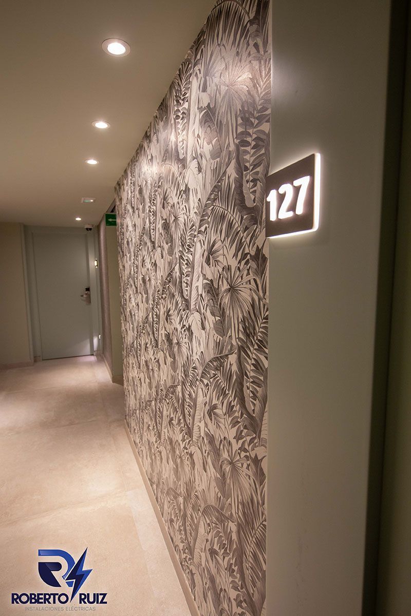 Un pasillo con un cuadro en la pared y el número 127 en la pared.