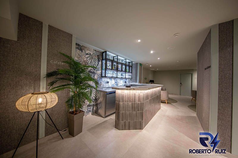 Un vestíbulo de hotel con un largo mostrador y una lámpara.