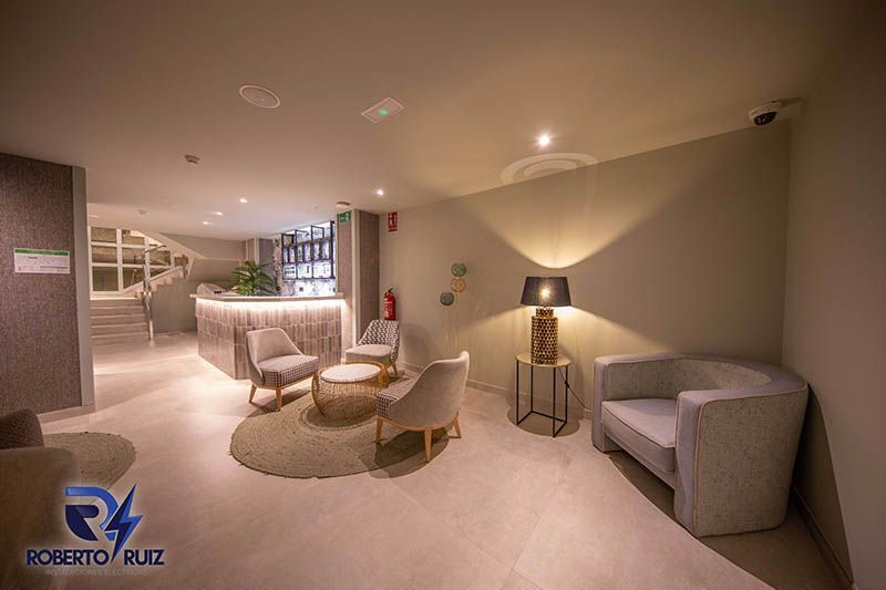 Una sala de estar con sofá, sillas, mesas y lámparas.