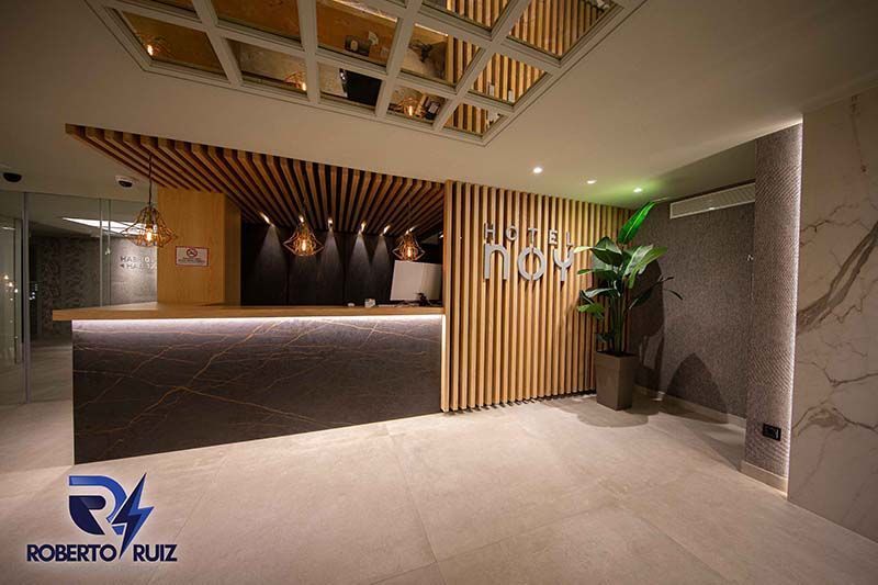 Un vestíbulo de hotel con un mostrador de recepción y una planta.