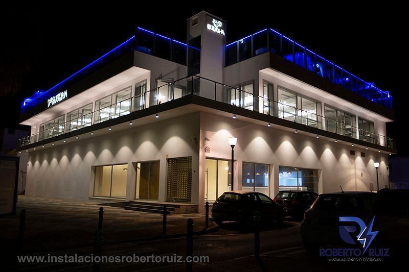Un gran edificio con muchas ventanas está iluminado por la noche.