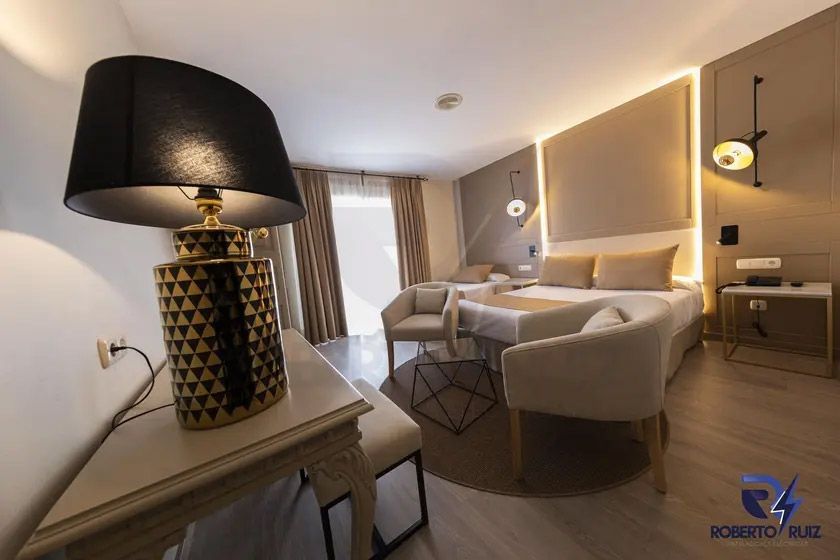 Una lámpara está sobre una mesa en una habitación de hotel.