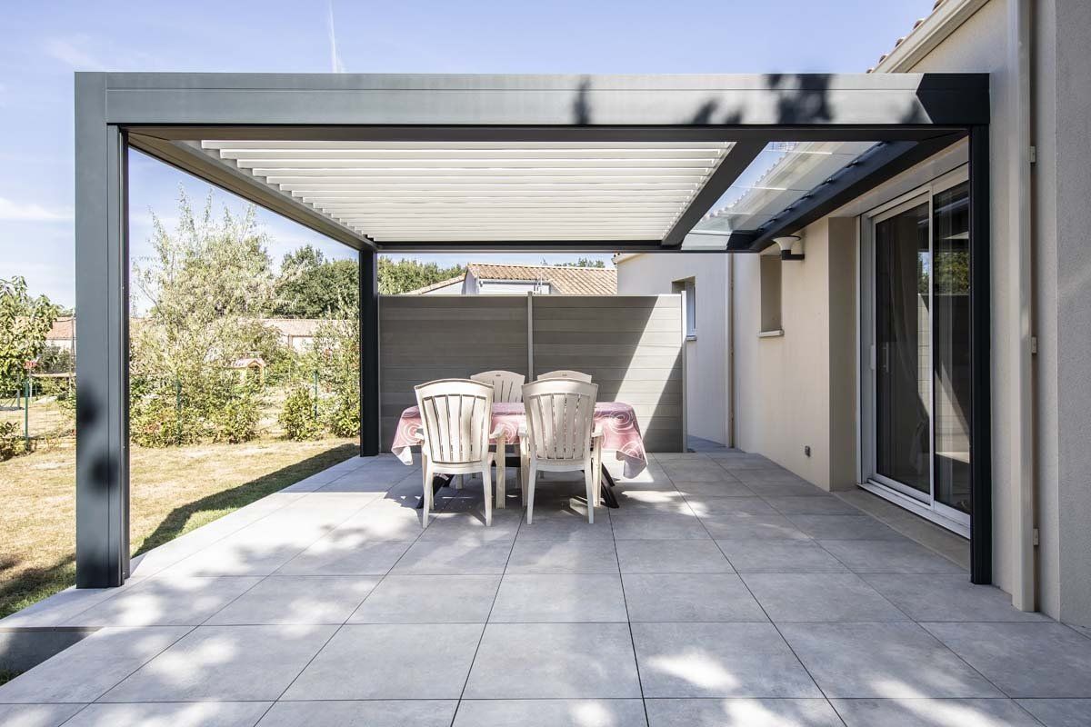 Pergola bioclimatique adossée à la façade et poteaux déportés