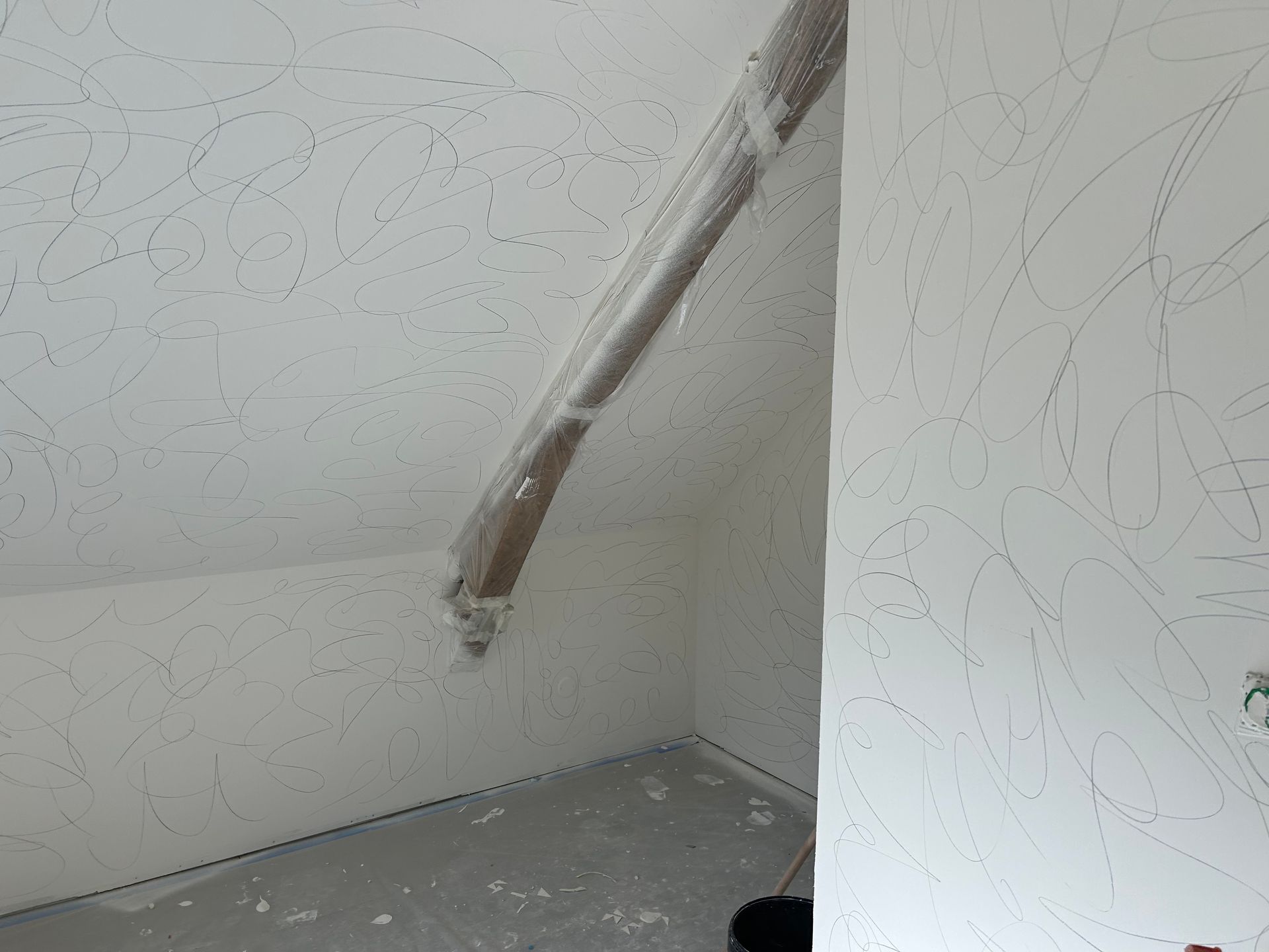Application d’enduit mural avec une spatule lors de travaux de rénovation intérieure.