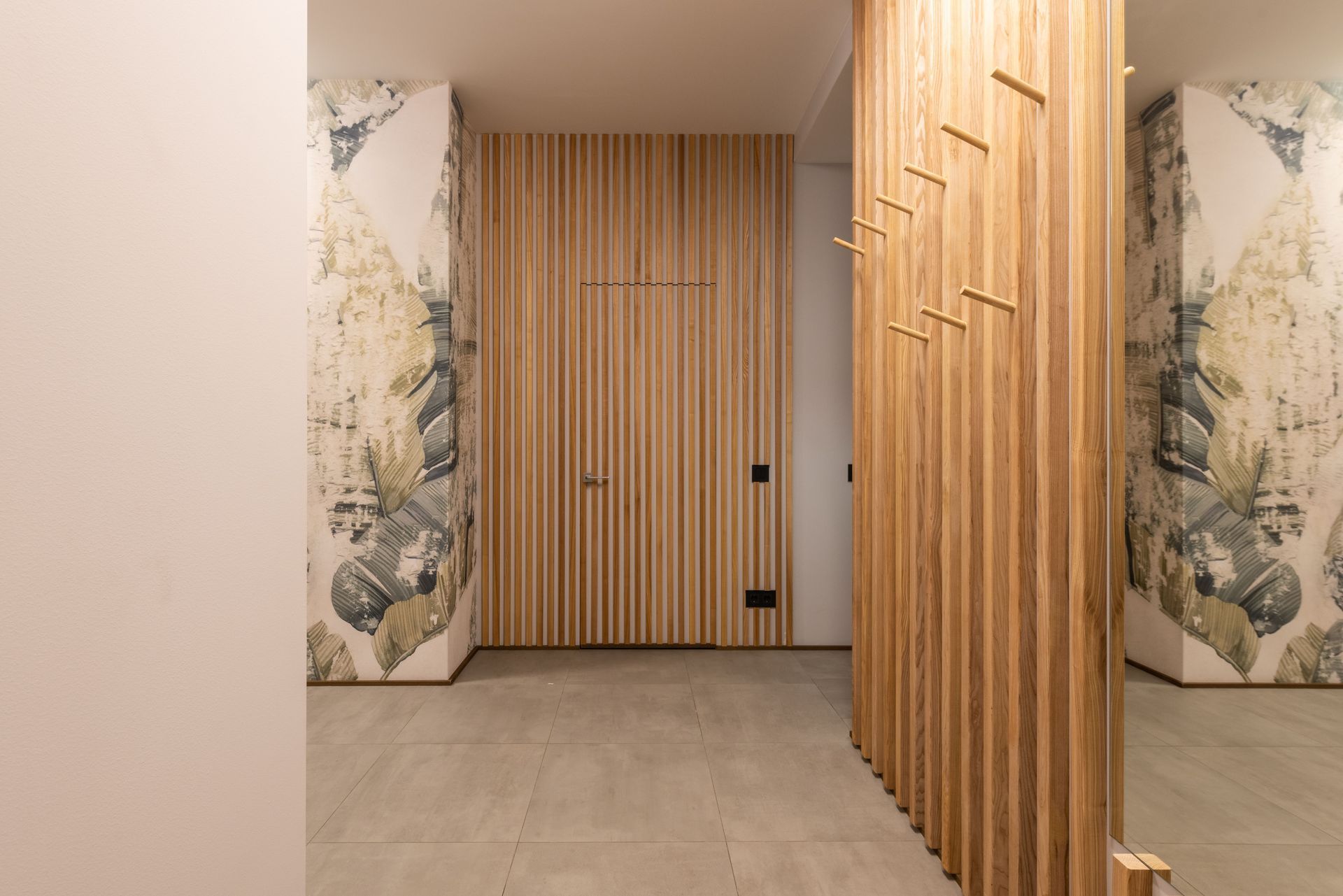 Couloir avec panneaux en bois et tapisserie florale.