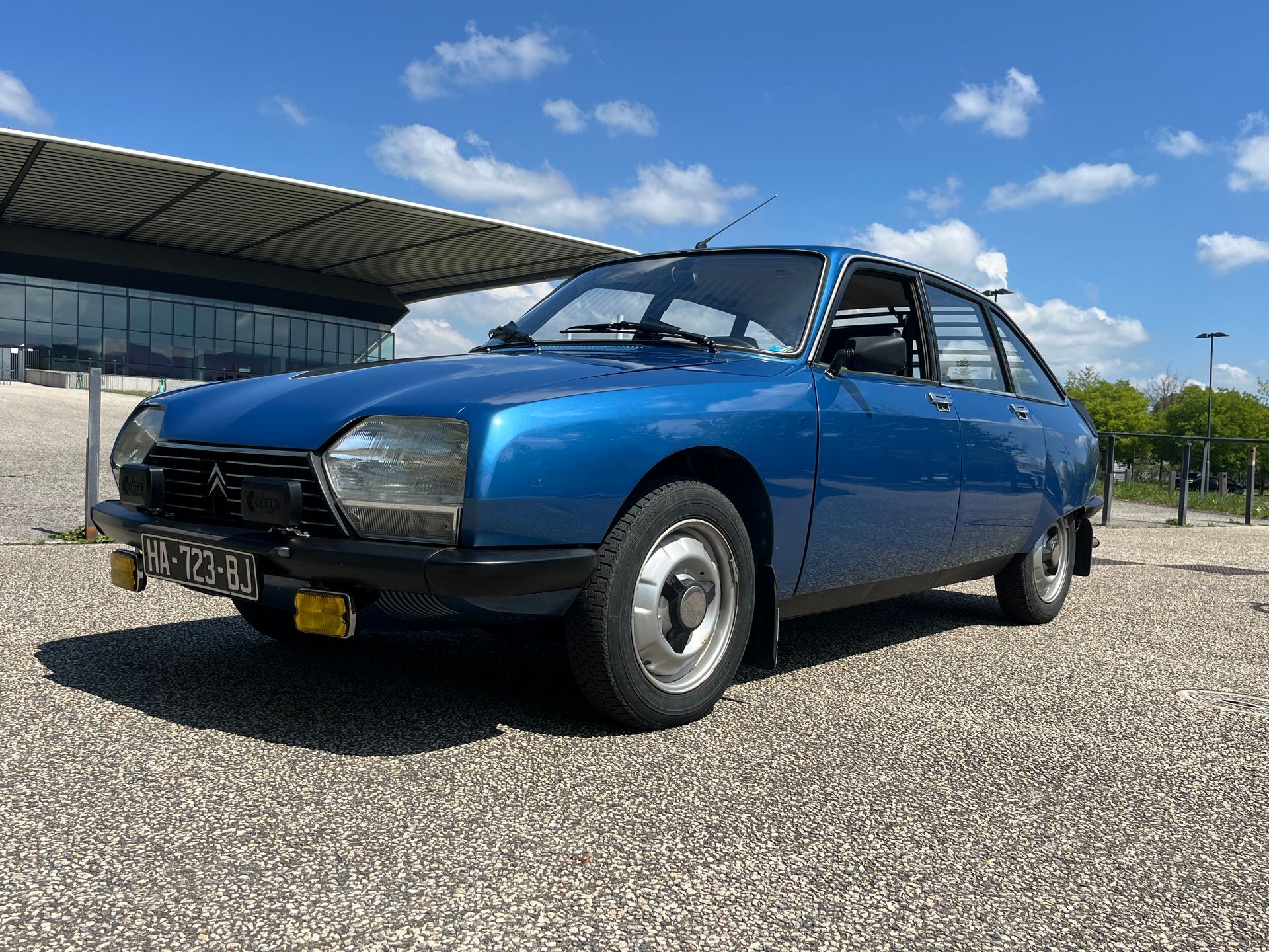 Une voiture bleue devant un bâtiment