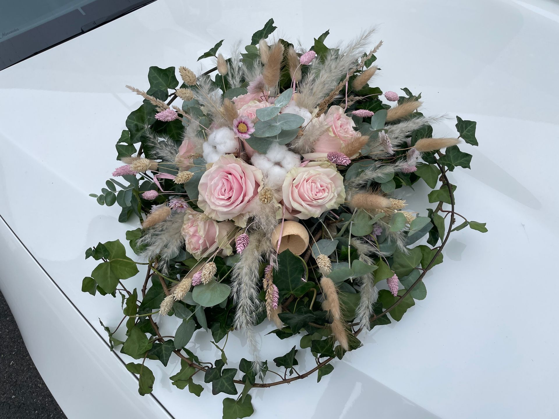 Un bouquet de fleurs roses sur une voiture blanche
