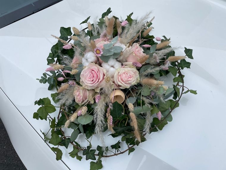 Un bouquet de fleurs roses sur une voiture blanche