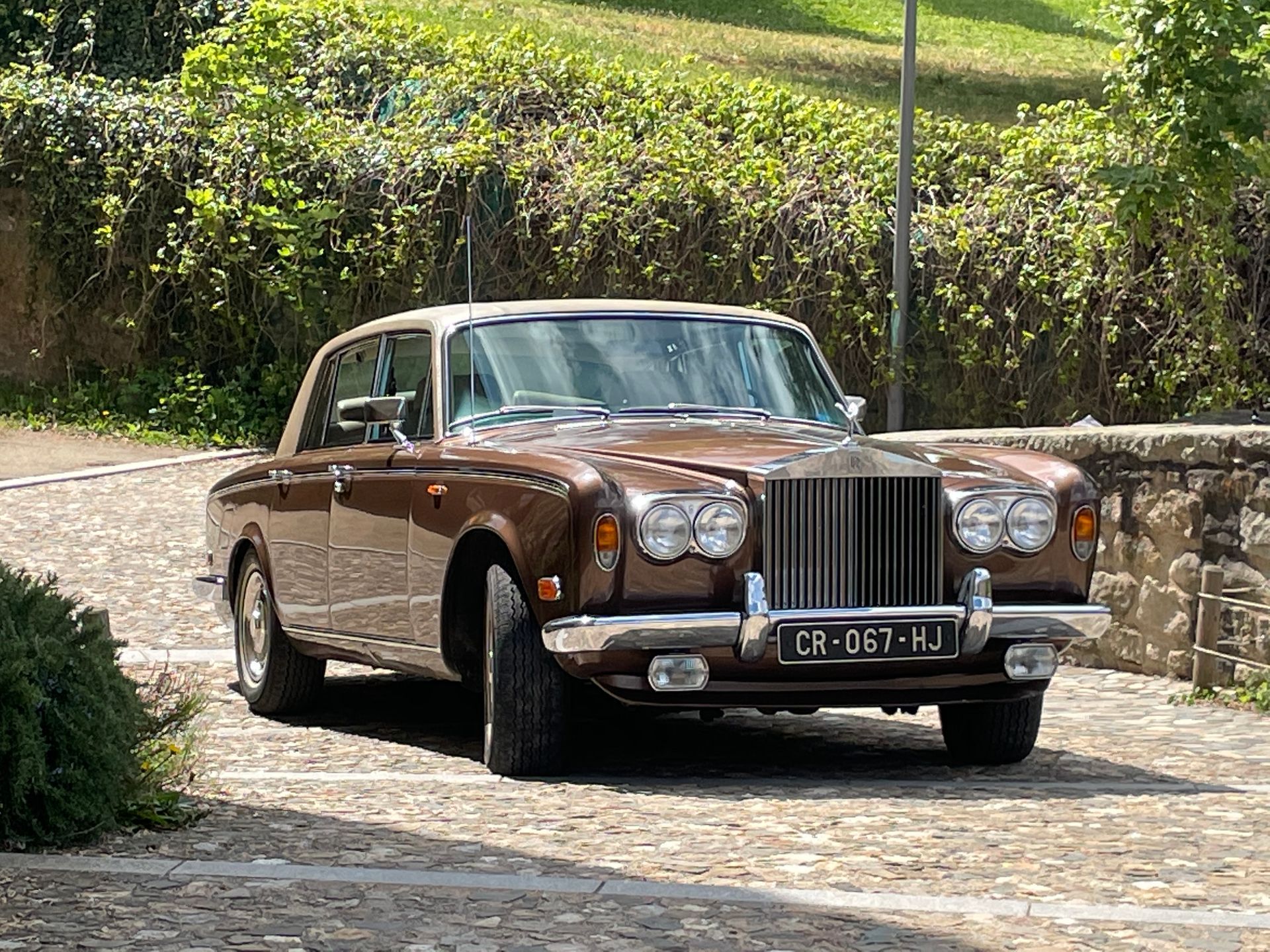 Une voiture ancienne devant un muret