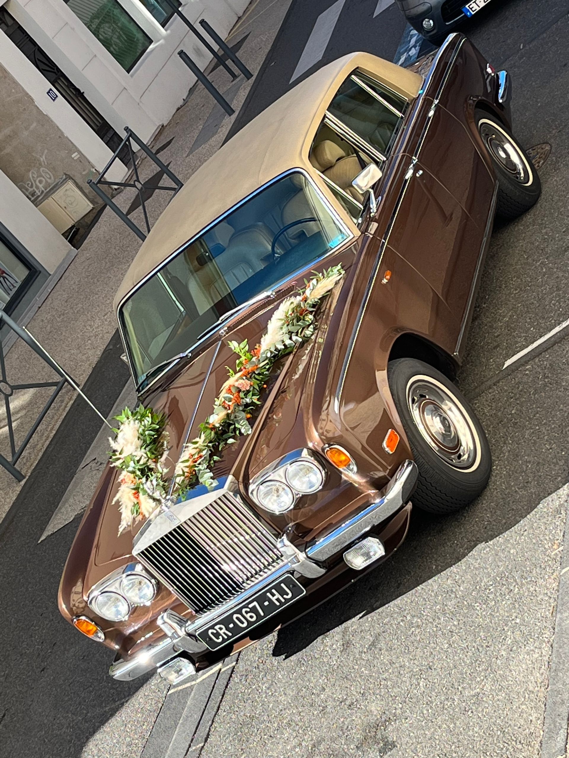 Une voiture avec une guirlande de fleurs