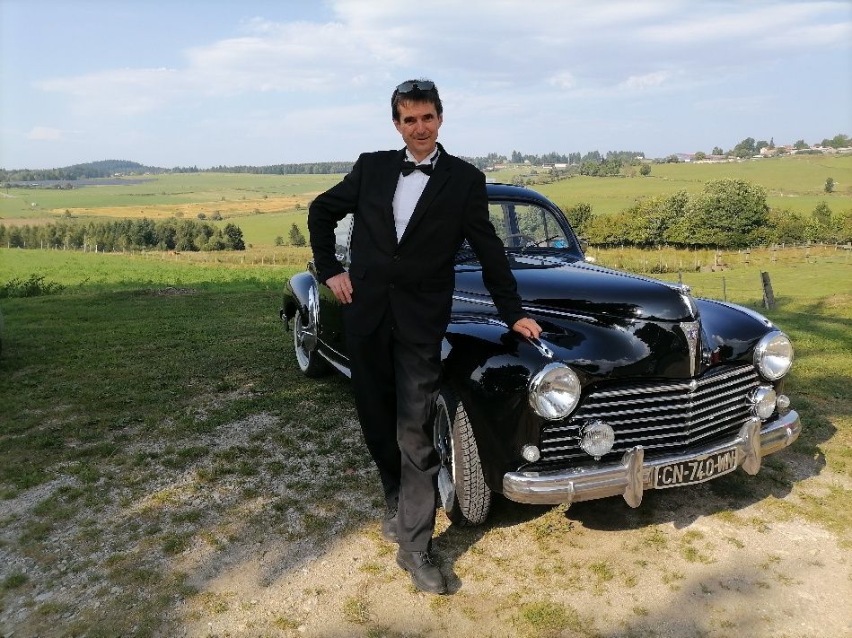 Un chauffeur devant une voiture noire