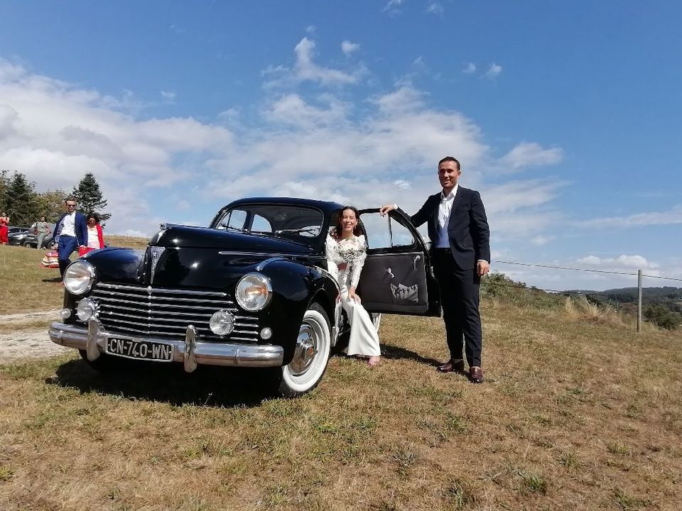 Deux mariés avec une ancienne voiture noire