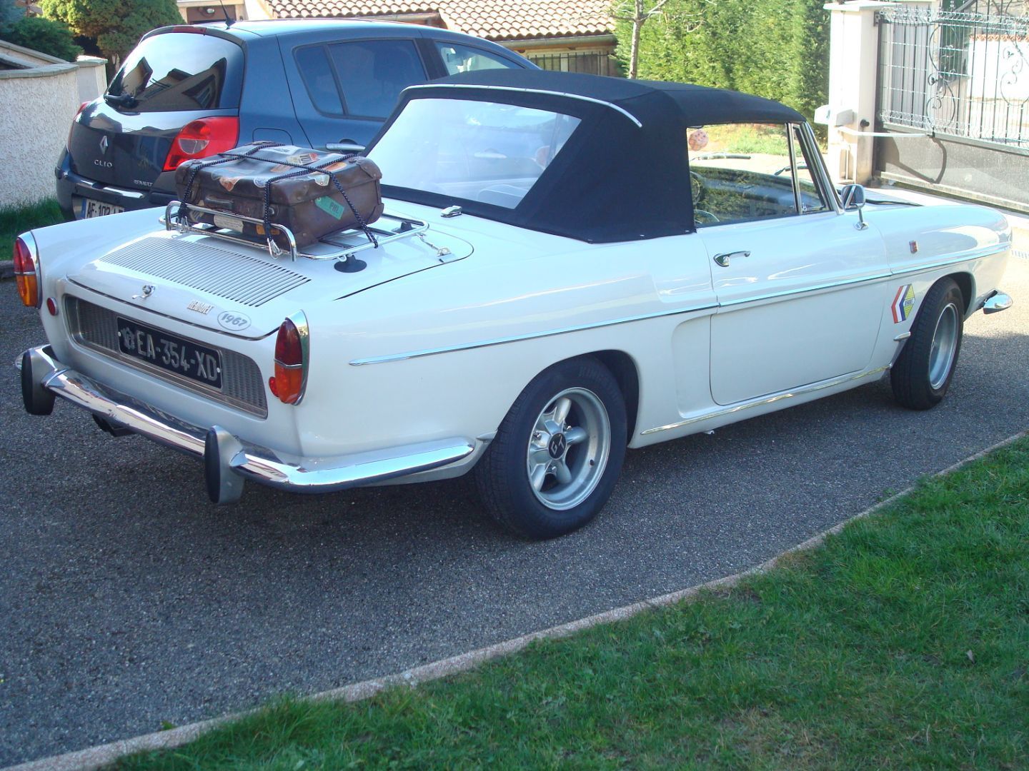 Une voiture blanche avec une valise dessus