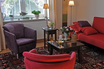 Ein Wohnzimmer mit einem roten Sofa und lila Stühlen