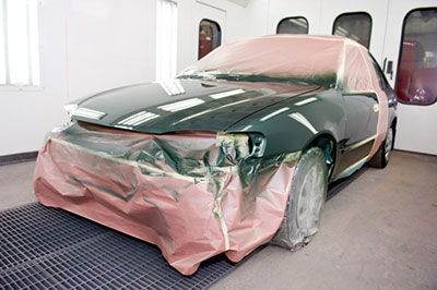 Se está pintando un coche en una cabina de pintura.