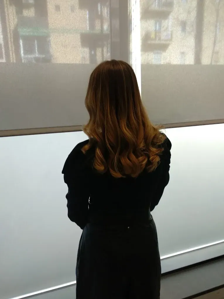 Persona de pie de espaldas a la cámara en un pasillo con poca luz, mirando una pantalla proyectada.