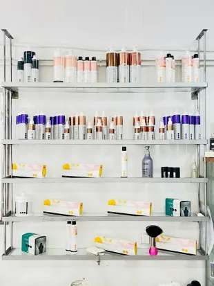 Estantes de pared repletos de productos cosméticos y para el cuidado de la piel surtidos en botellas y cajas.