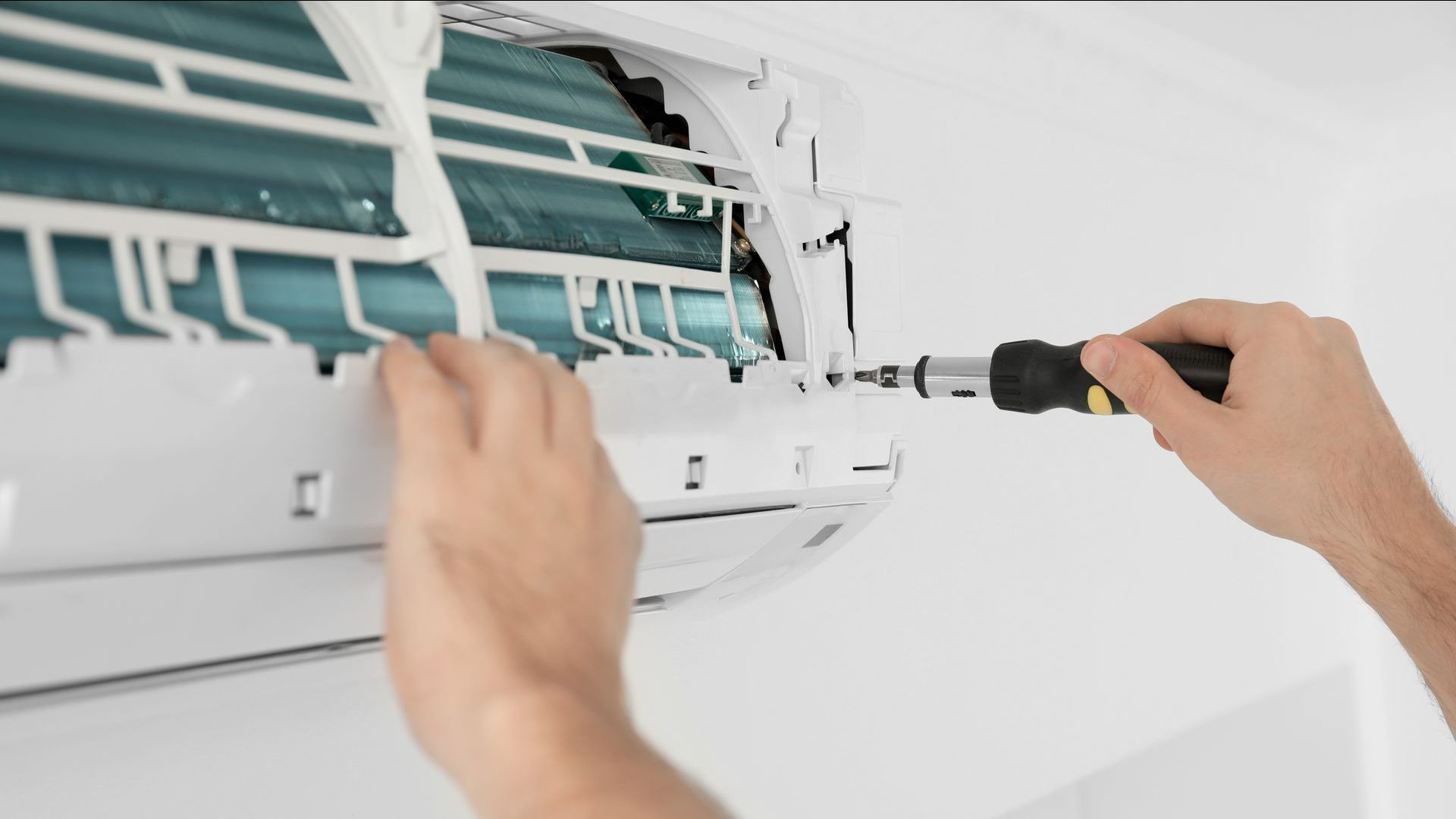 Plombier professionnel qui entretien une climatisation murale