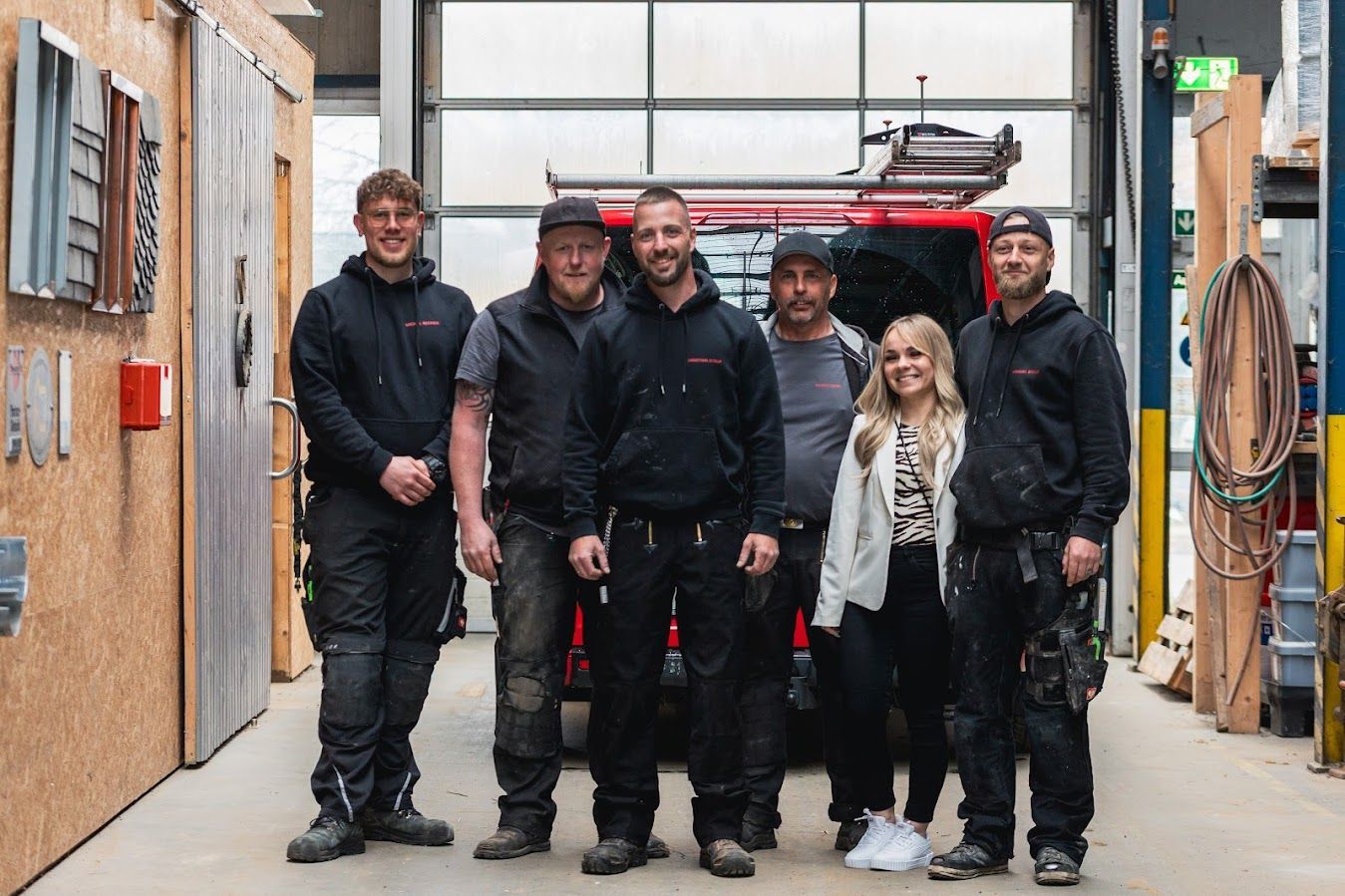 Sechs Menschen stehen im Kreis und halten ihre Fäuste aneinander.