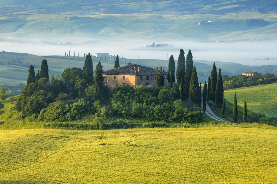 A country house surrounded by trees and fields