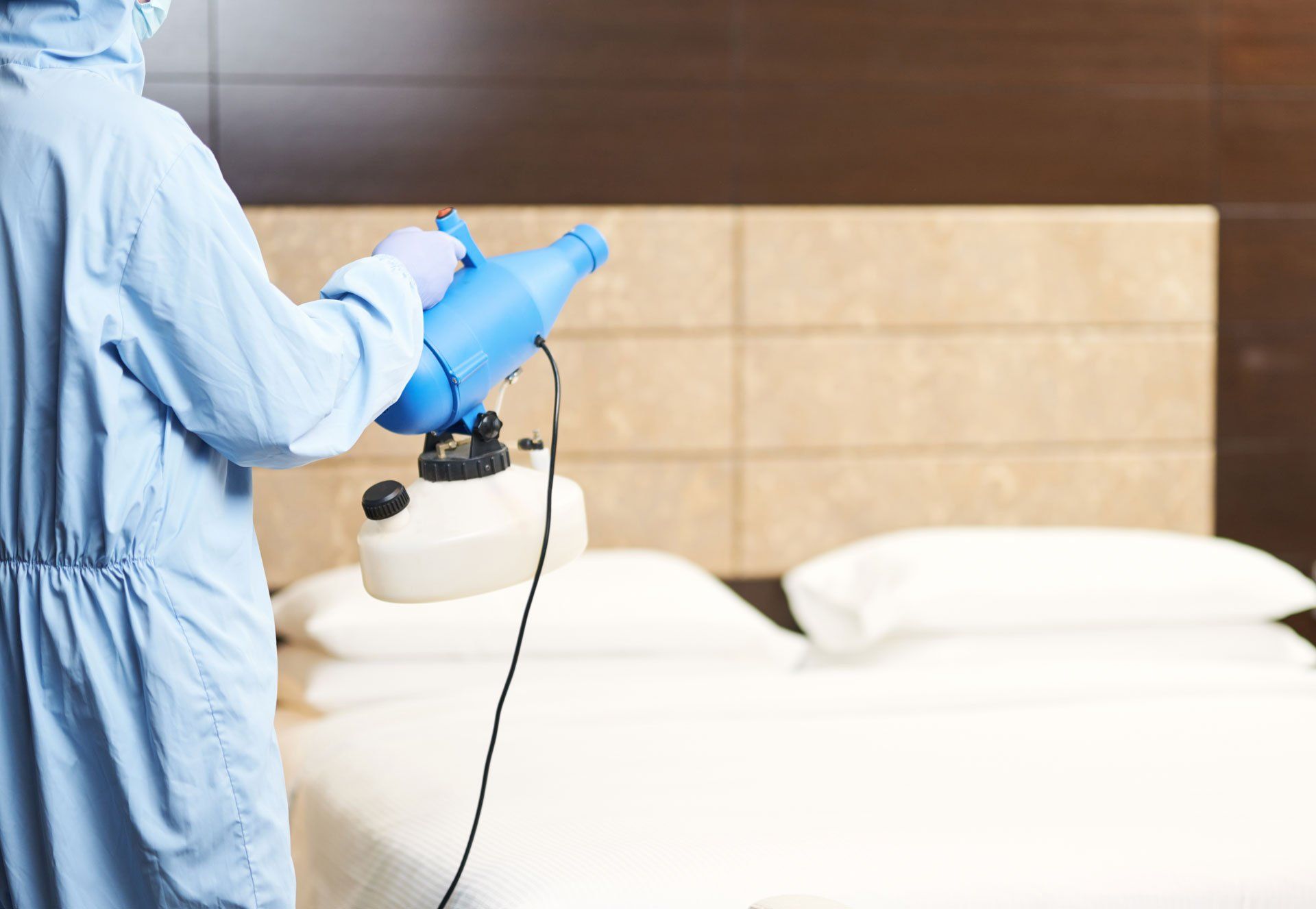 Technicien désinfectant une chambre par micro vaporisation