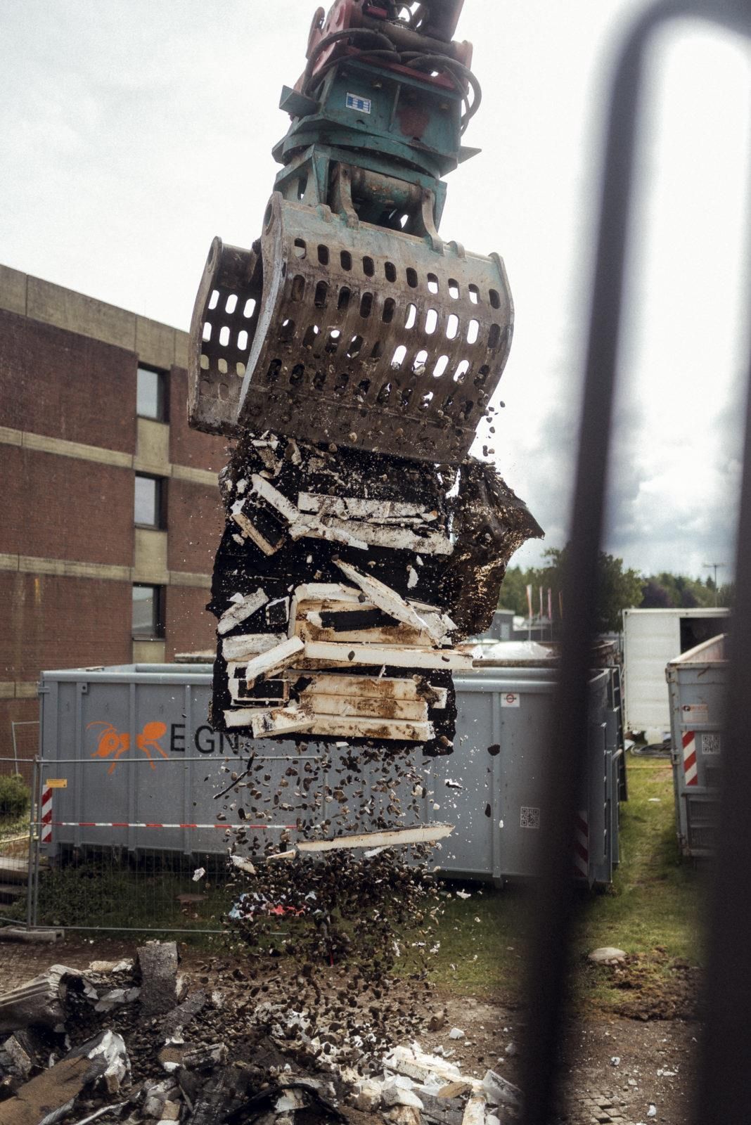 Ein Kran hebt ein großes Stück Metall in die Luft.