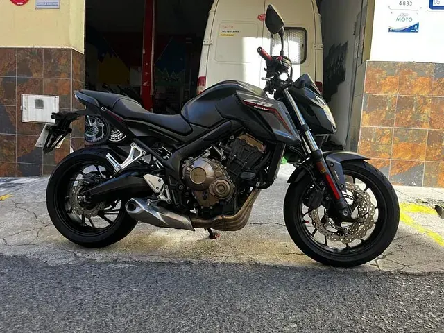 Una motocicleta negra está estacionada frente a un edificio.