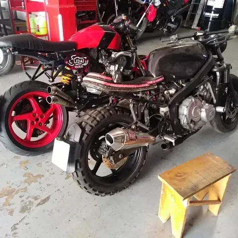 Dos motocicletas están estacionadas una al lado de la otra en un garaje.
