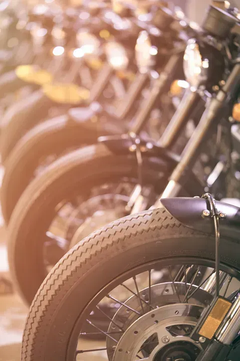 Una fila de motocicletas están estacionadas una al lado de la otra en un garaje.