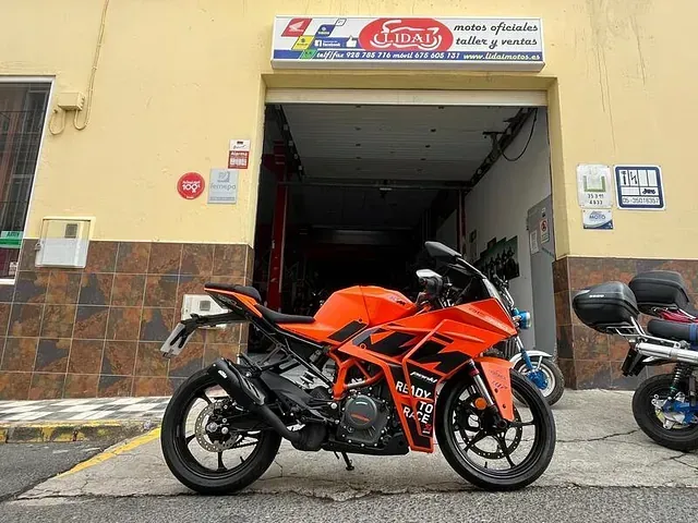 Una motocicleta naranja está estacionada frente a un edificio.