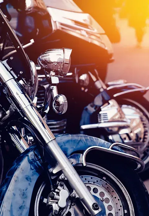 Dos motocicletas están estacionadas una al lado de la otra al costado de la carretera.