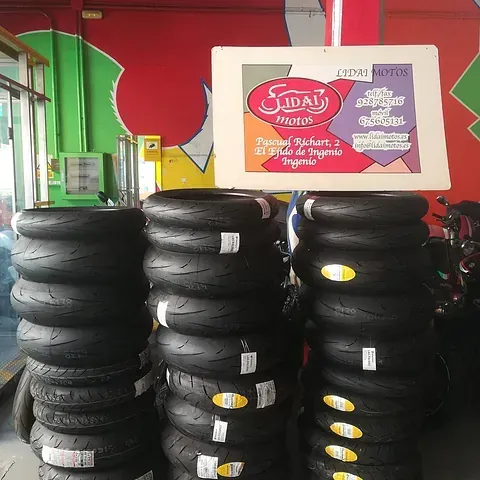 Una pila de neumáticos de motocicleta con un cartel encima que dice Jidai Motors
